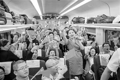 10月1日,乘客们在列车上共同庆祝新中国成立70周年。 兰州局集团供图 10月1日,乘客们在列车上共同庆祝新中国成立70周年。 兰州局集团供图